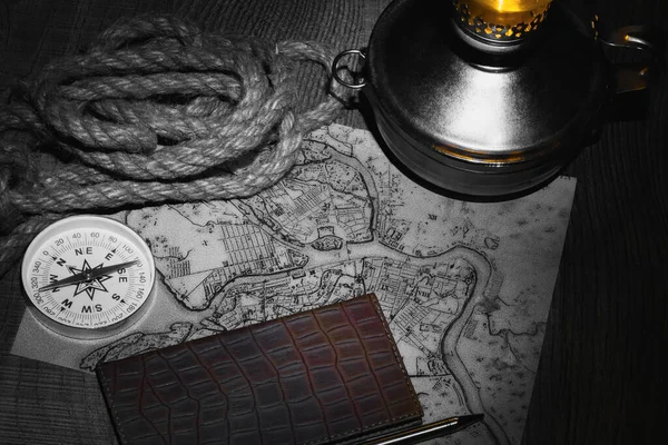 计划晚上在煤油灯的灯光下 在餐桌边旅行 研究带有指南针的旧地图并给笔记本写信 — 图库照片
