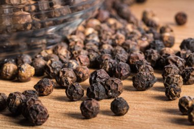 Ahşap zemin üzerinde kara biber taneleri.