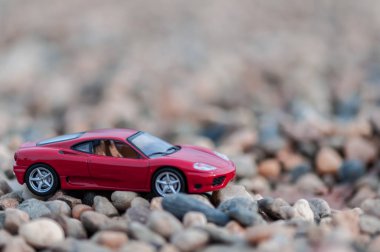 Çakıl kırmızı modern oyuncak araba. Sığ derinlik-in tarla.