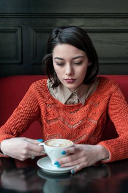 Masada oturan ve kahve içme kadın. Gerçek insanlar.