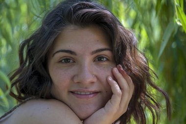 Söğüt ağacının altında yeşil yapraklı bir kadın portresi