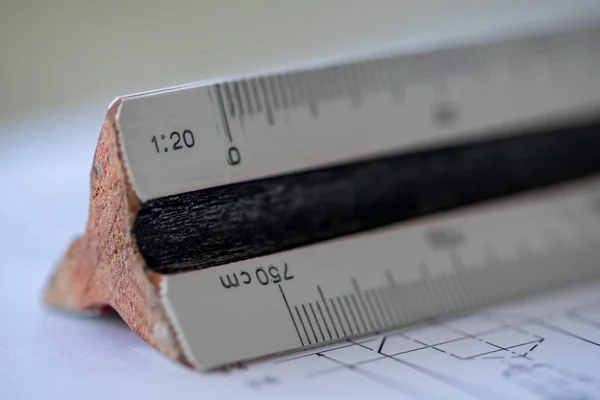 Close-up of a wooden ruler with a blueprint in the background. Architect tools. Selective focus.