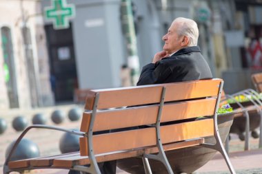 Timisoara, Romanya - 17 Kasım 2019: Bir adam bankta dinleniyor. Gerçek insanlar..