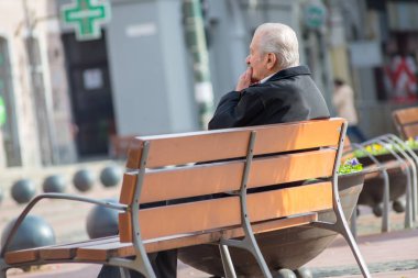 Timisoara, Romanya - 17 Kasım 2019: Bir adam bankta dinleniyor. Gerçek insanlar..