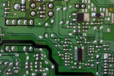 Elektronik bileşenlere yakın çekim. KİS dirençleri, kapasitörler, indüktörler ve entegre devreler.