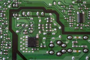 Elektronik bileşenlere yakın çekim. KİS dirençleri, kapasitörler, indüktörler ve entegre devreler.
