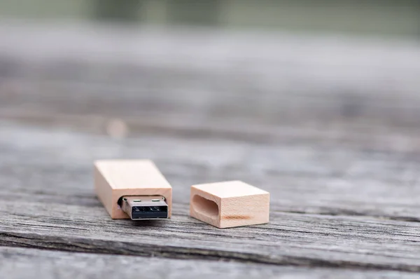 Close-up of a wooden pen drive, flash disk sitting on a table.