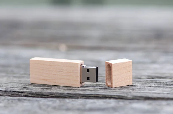 Close-up of a wooden pen drive, flash disk sitting on a table.