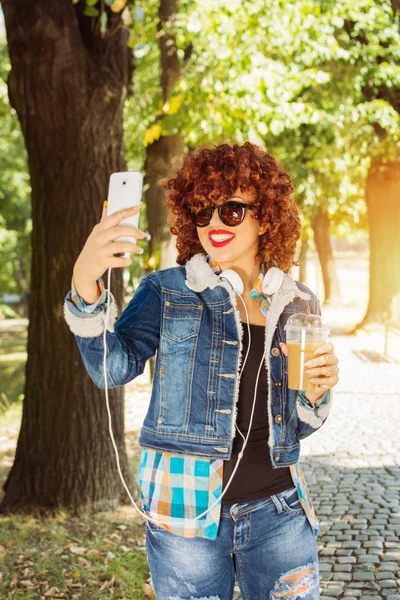 Feliz milenaria adolescente tomando una selfie en el parque en otoño —  Fotos de Stock