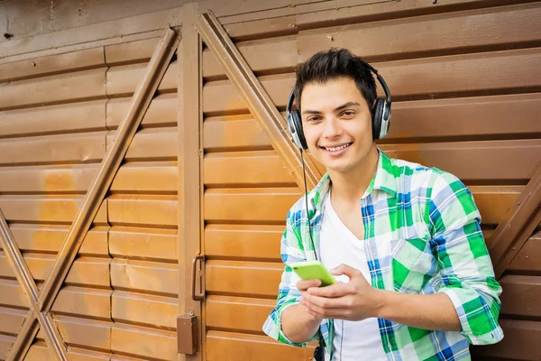 Joven chico millennial con auriculares y teléfono inteligente escuchando música —  Fotos de Stock