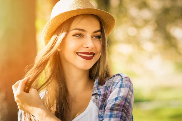 Krásná mladá žena v parku v podzimní usmívá — Stock fotografie