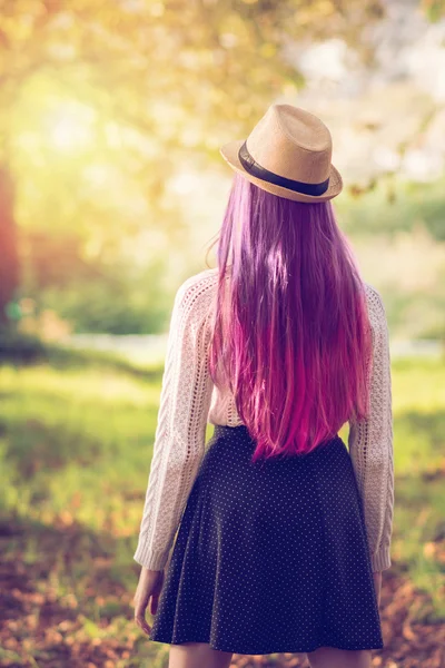 在户外在公园的秋天长紫色和粉红色头发的年轻女子 — 图库照片
