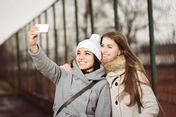 Two teenage girls in autumn outdoors taking a selfie — Stock Photo, Image