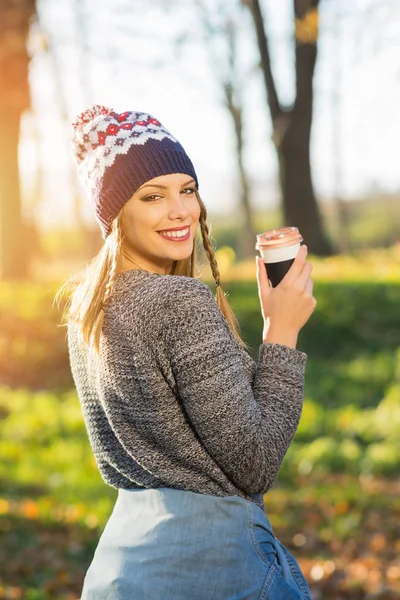 Jovem mulher moderna com café ao ar livre no parque no outono — Fotografia de Stock