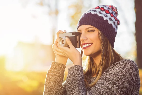 Fotógrafo feminino milenar moderno ao ar livre tirando uma foto usando câmera analógica — Fotografia de Stock