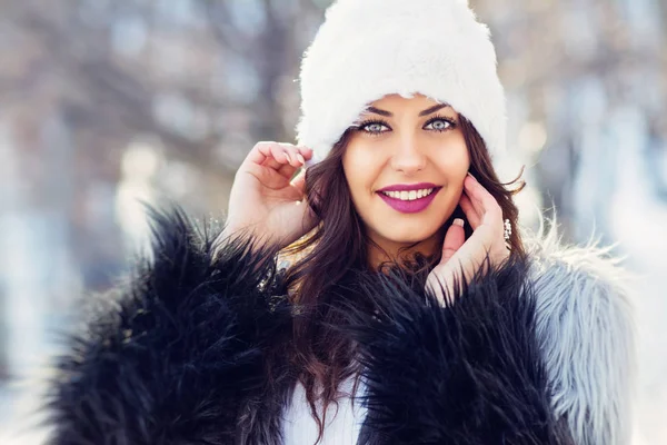 Gorgeous young brunette woman in fur hat and coat outdoors in winter — Stock Photo, Image