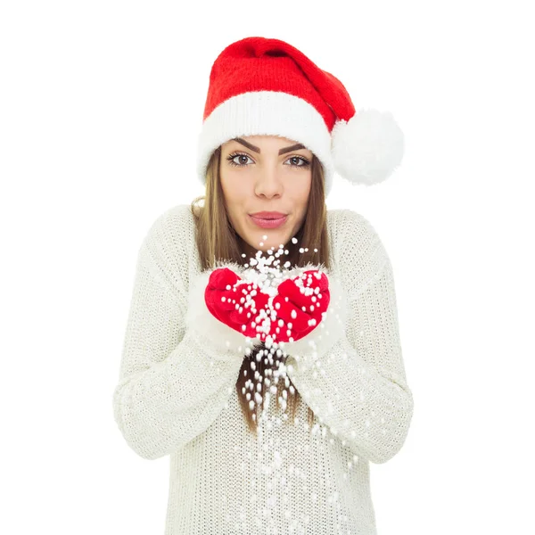 Hermosa joven en Santa sombrero sosteniendo y soplando nieve — Foto de Stock