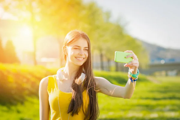 Adolescente mignonne prenant un selfie dans le parc en été — Photo