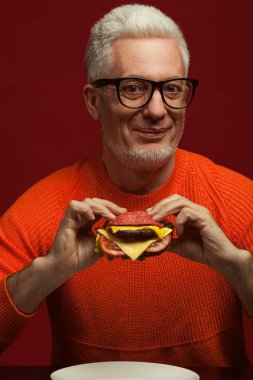 Sağlıksız yeme. Abur cubur kavramı. Burger ile moda olgun adam portresi