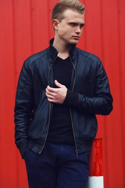 Portrait of blue-eyed young man with short blond hair wearing black jacket — Stock Photo, Image