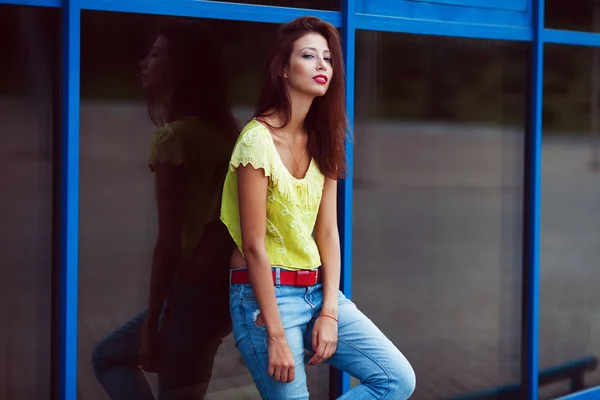 Usmívající se dívka bederní v modré džíny v městě letní. — Stock fotografie
