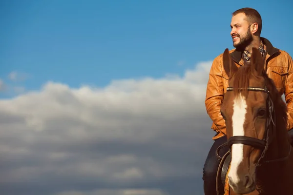 Conceito de vida no campo. Jovem relaxado e sorridente homem rico equitação cavalo — Fotografia de Stock