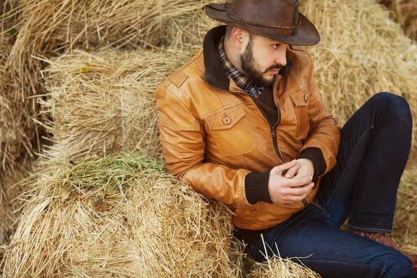 Country life concept. Young relaxed man in light brown leather jacket