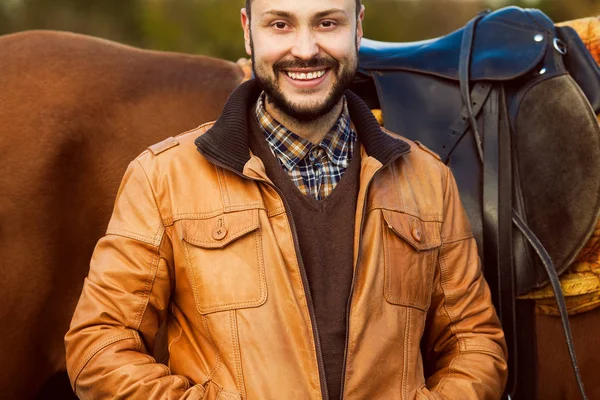 Conceito de vida no campo. Jovem relaxado e sorrindo homem rico em jaqueta de couro — Fotografia de Stock