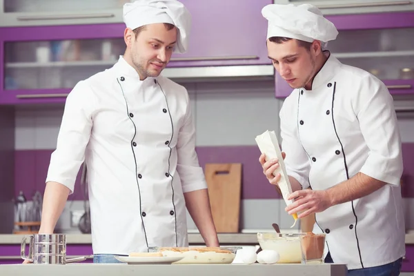 Tiramisu vaření koncept. Portrét dvou mužů s úsměvem v uniformě kuchař — Stock fotografie