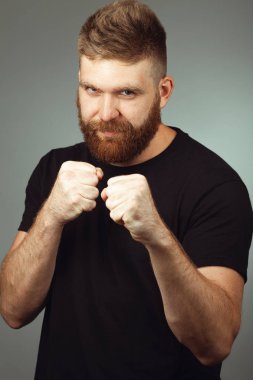 Orta yaşlı, yakışıklı, kızıl saçlı, gri arka planda bir sporcu. 