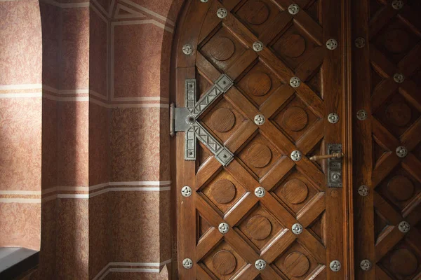 Wooden door with metal decoration in marble house. Natural light. Indoor shot