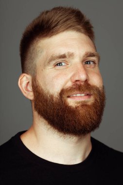 Her yaşta müthiştir. Koyu gri arka planda duran 30 yaşındaki karizmatik kaslı adamın yakın portresi. Mükemmel saç kesimi. Rock 'çı, motorcu, hipster tarzı. Stüdyo çekimi