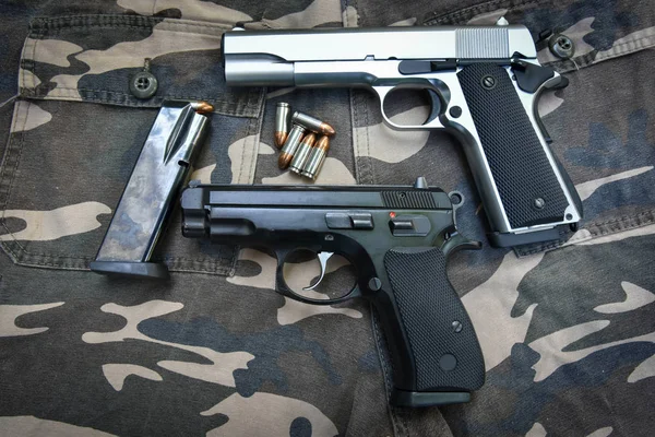 Duas pistolas semi-automáticas e saco em calça soldado camuflagem — Fotografia de Stock