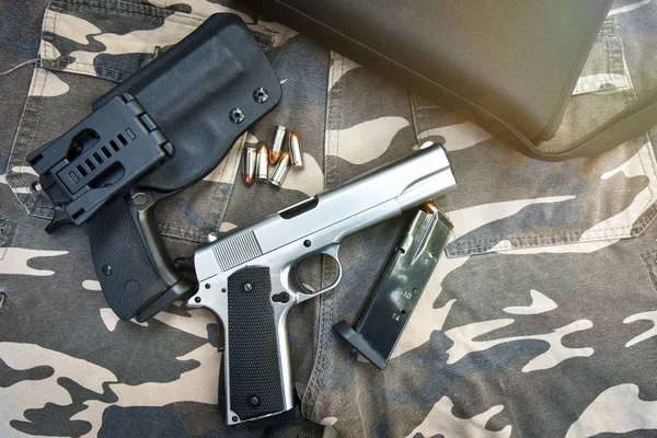 Pistolas y bolso en pantalón de soldado de camuflaje — Foto de Stock