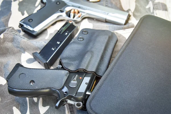 Pistolas y bolso en pantalón de soldado de camuflaje — Foto de Stock