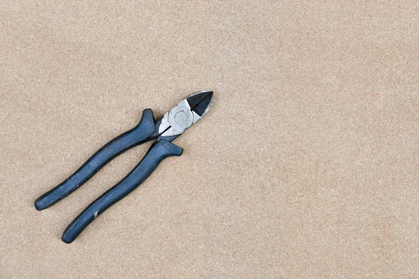 Close up of black handled wire cutter on wood background — Stock Photo, Image