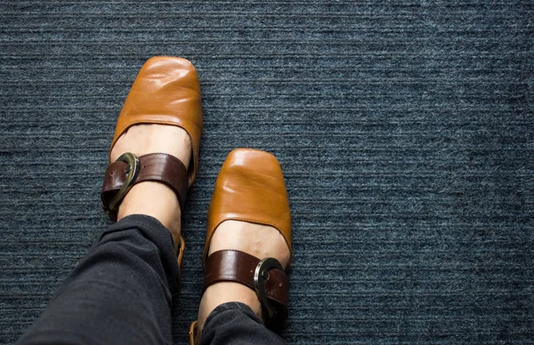 地毯地板上棕色真皮靴子的顶部视图 地毯背景棕色皮鞋 — 图库照片