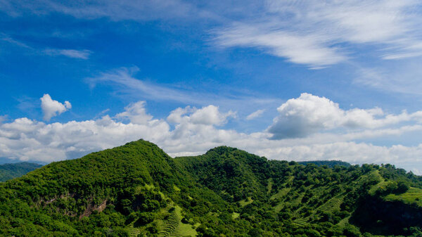 Aerial landscape view of green mountains and blue sky