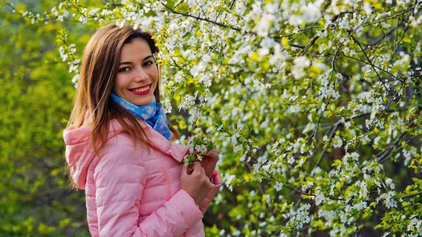 Mooi meisje in een bloeiende kersen tuin. — Stockfoto