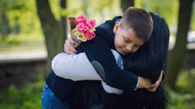 Küçük şirin çocuk sarılmak Park annesiyle.
