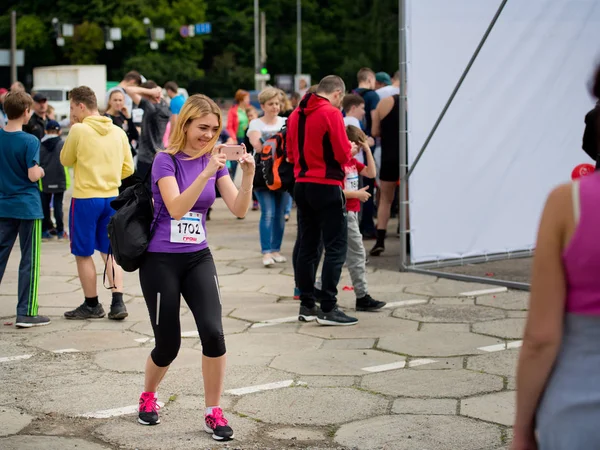 Vinnytsia ukraine - 27. Mai 2017: jährlicher Stadtlauf "vinnytsia runs". ein Mädchen nimmt an einem Rennen teil und fotografiert mit ihrem Handy. — Stockfoto