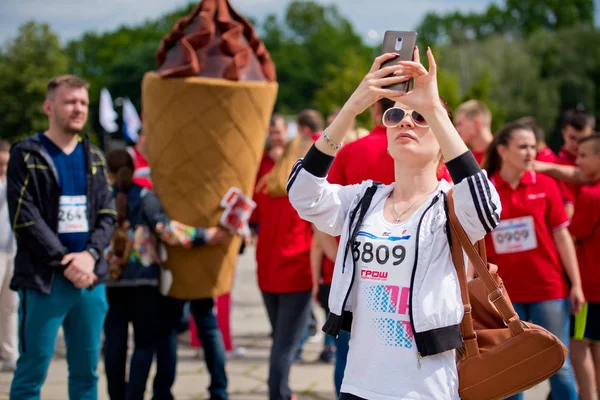 Vinnytsia ukraine - 27. Mai 2017: jährlicher Stadtlauf "vinnytsia runs". ein Mädchen nimmt an einem Rennen teil und fotografiert mit ihrem Handy. — Stockfoto