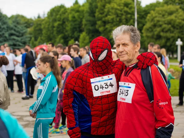 Vinnytsia Ukraine - 27 de maio de 2017: Annual City Run "Vinnytsia Runs". Um idoso da raça masculina participante, é fotografado com um personagem Homem-Aranha . — Fotografia de Stock