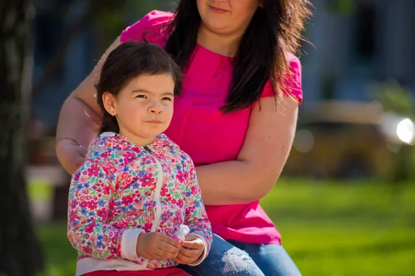 Мама делает прическу своей очаровательной дочери в парке на скамейке запасных. День Матери. Крупный план . — стоковое фото