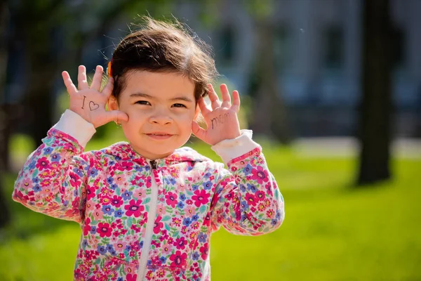 La inscripción en las palmas de "Amo a mamá". Pequeña niña dulce. Día de las Madres . — Foto de Stock