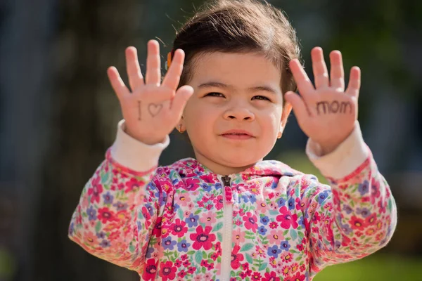 「お母さんが大好き」手のひらに刻まれた文字。甘い少女。母の日。顔に選択と集中. — ストック写真