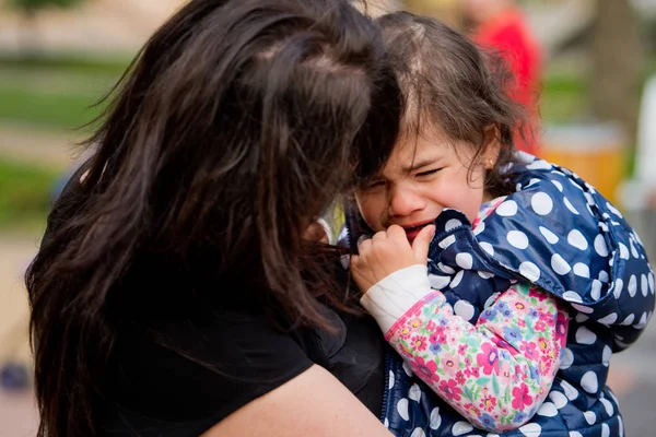 Ένα κοριτσάκι κλαίει στην αγκαλιά της. Ημέρα της μητέρας. — Φωτογραφία Αρχείου