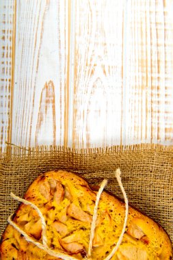 Taze ekmek. Beyaz ahşap zemin üzerinde çul üzerinde üstten görünüm pişmiş turta elmalı. Rustik tarzı.