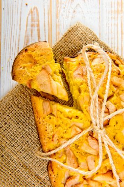 Taze ekmek. Beyaz ahşap zemin üzerinde çul üzerinde üstten görünüm pişmiş turta elmalı. Rustik tarzı.