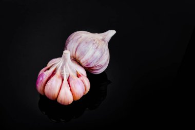 Taze sarımsak ampuller siyah bir zemin üzerine.